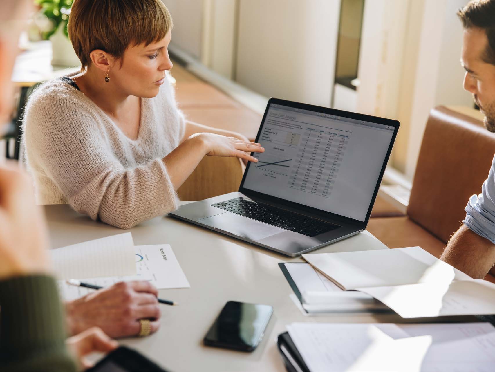 Profissionais analisando indicadores de vendas em um notebook
